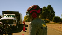 a man wearing a helmet is standing next to a truck